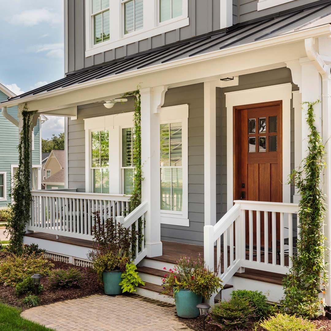 A house with gray siding, white trim, and a covered porch.