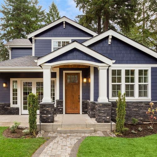 A house with white trim and blue shingle siding.